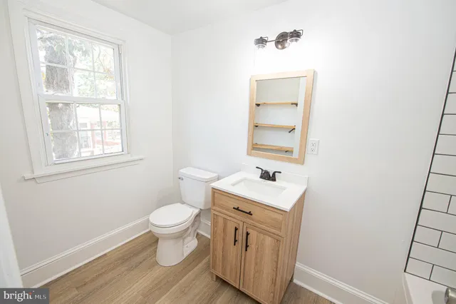a bathroom with a sink a toilet and a window