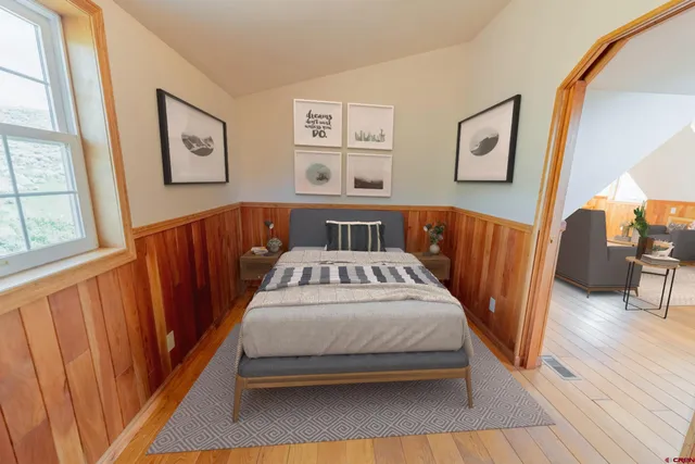 a bedroom with bed and wooden floor