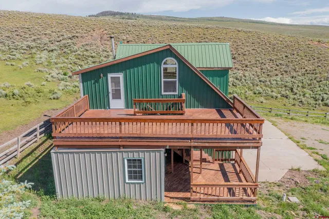 a view of a house with large windows and wooden fence