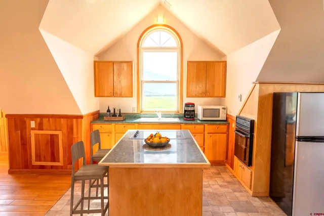 a view of a kitchen with a tub and a large window