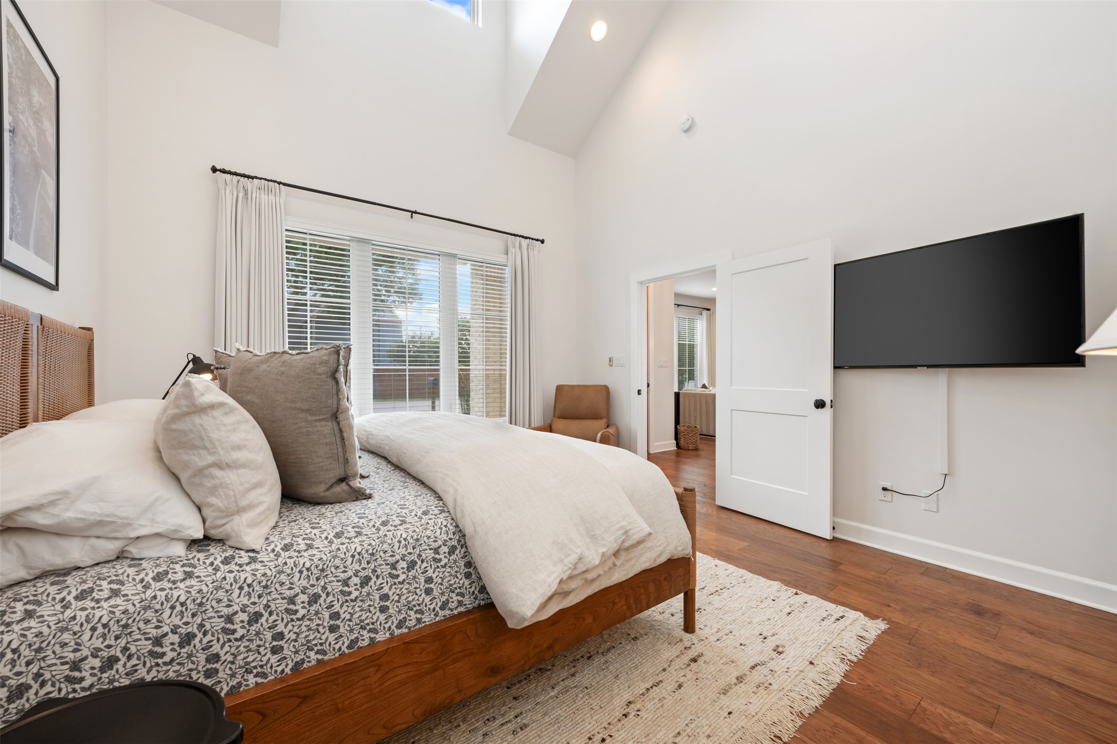 1301 West Street Georgetown, TX 78626 - Photo 20 of 40 A spacious bedroom featuring rich hardwood flooring and abundant natural light from a large sliding glass door and skylight.
