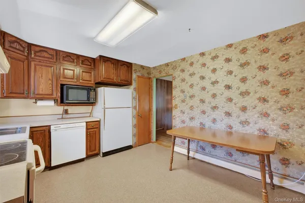 a kitchen with stainless steel appliances kitchen island granite countertop a refrigerator and a stove top oven