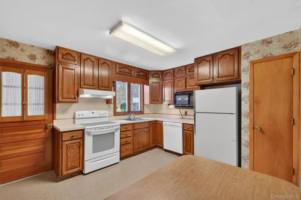 a kitchen with stainless steel appliances granite countertop a refrigerator a stove top oven a sink and dishwasher