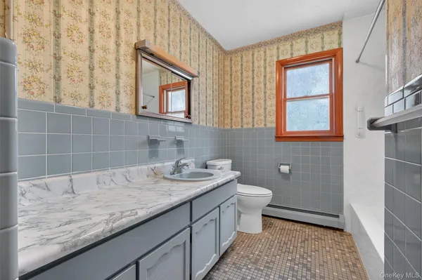 a bathroom with a granite countertop sink mirror vanity and toilet
