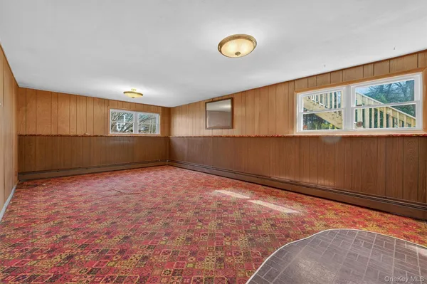 a view of an empty room with wooden floor and window