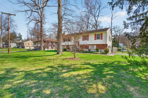 a view of a house with a backyard and a tree