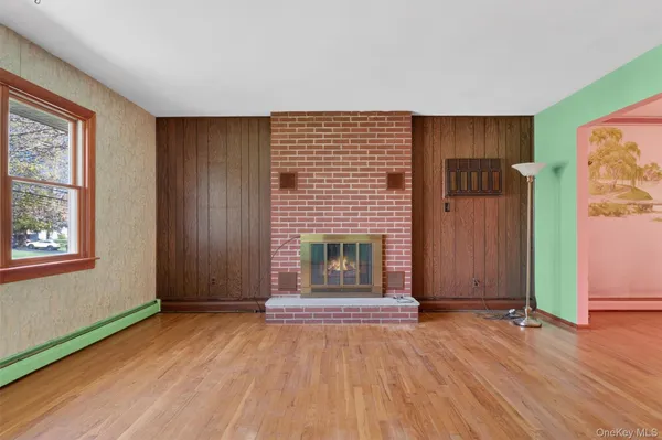 an empty room with windows and fireplace