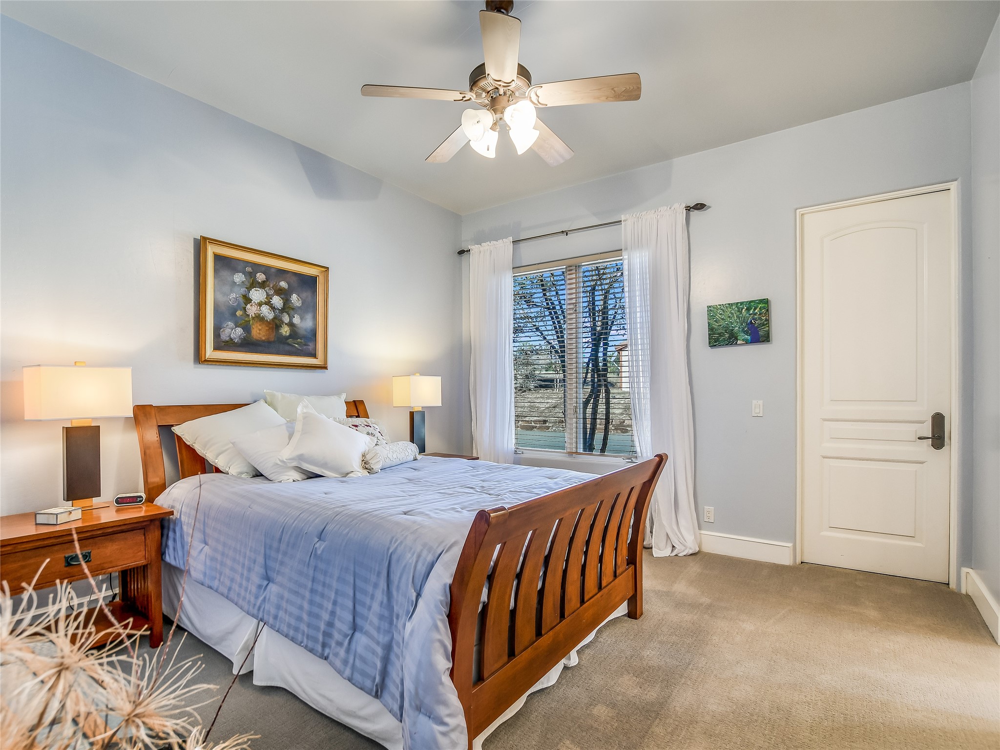 25909 Hamilton Pool Road Round Mountain, TX 78663 - Photo 12 of 34 a bedroom with a bed and a chandelier