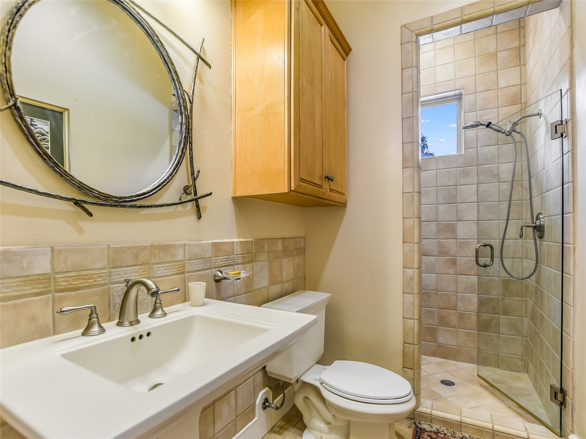 25909 Hamilton Pool Road Round Mountain, TX 78663 - Photo 15 of 34 a bathroom with a sink a toilet and a mirror