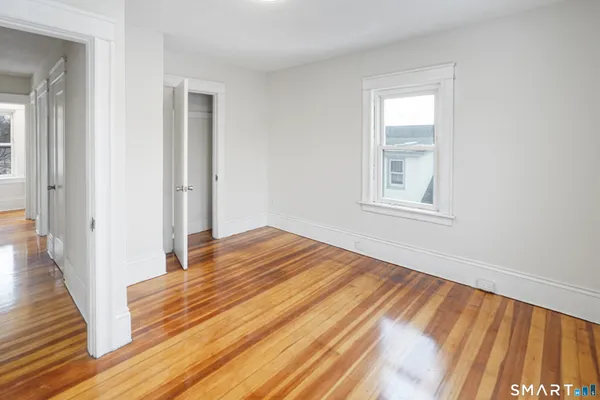 a view of a room with wooden floor and window
