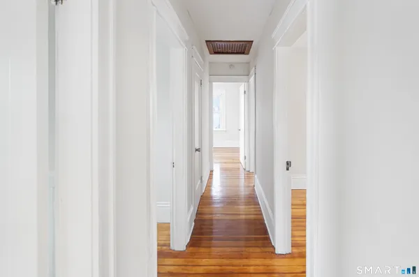 a view of a hallway with wooden floor