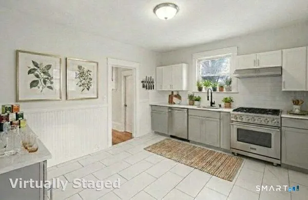 a kitchen with a sink a stove top oven and cabinets