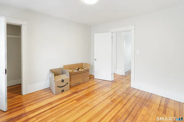 a room with a bed and wooden floor