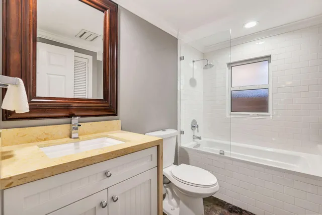 a bathroom with a granite countertop toilet sink and mirror