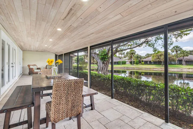 a dining room with furniture water view and a floor to ceiling window
