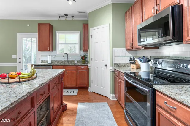 a kitchen with stainless steel appliances granite countertop a sink stove and cabinets