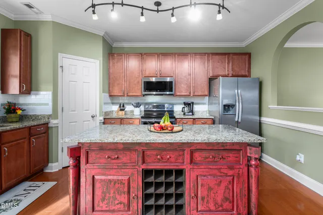 a kitchen with stainless steel appliances granite countertop a stove refrigerator and cabinets