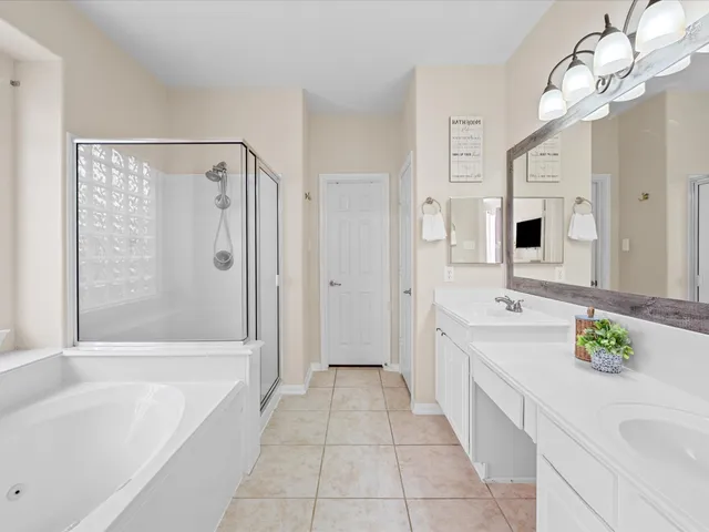 a spacious bathroom with a granite countertop tub sink a mirror a shower and a bathtub