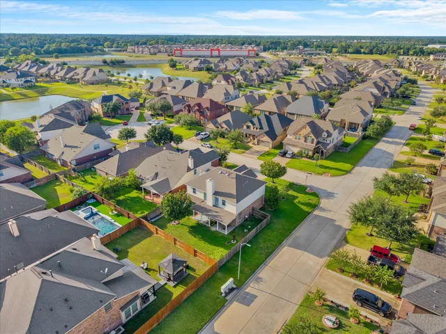 an aerial view of a house with a swimming pool lake and mountain view