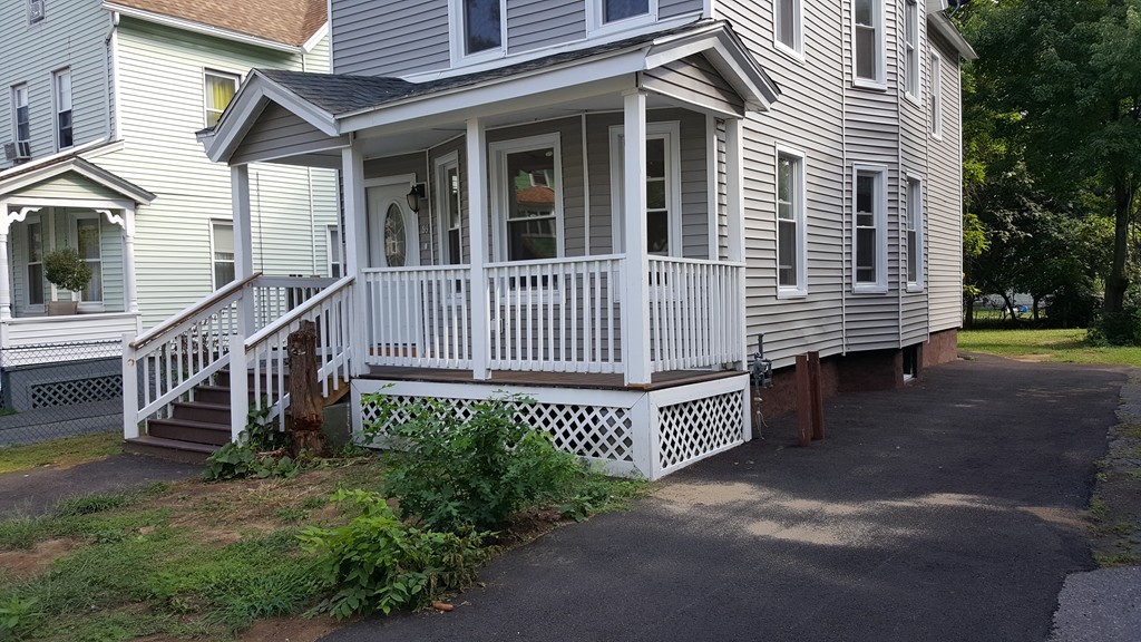 99 Alden Street Springfield, MA 01109 - Photo 3 of 21 a view of a house with a yard and wooden fence
