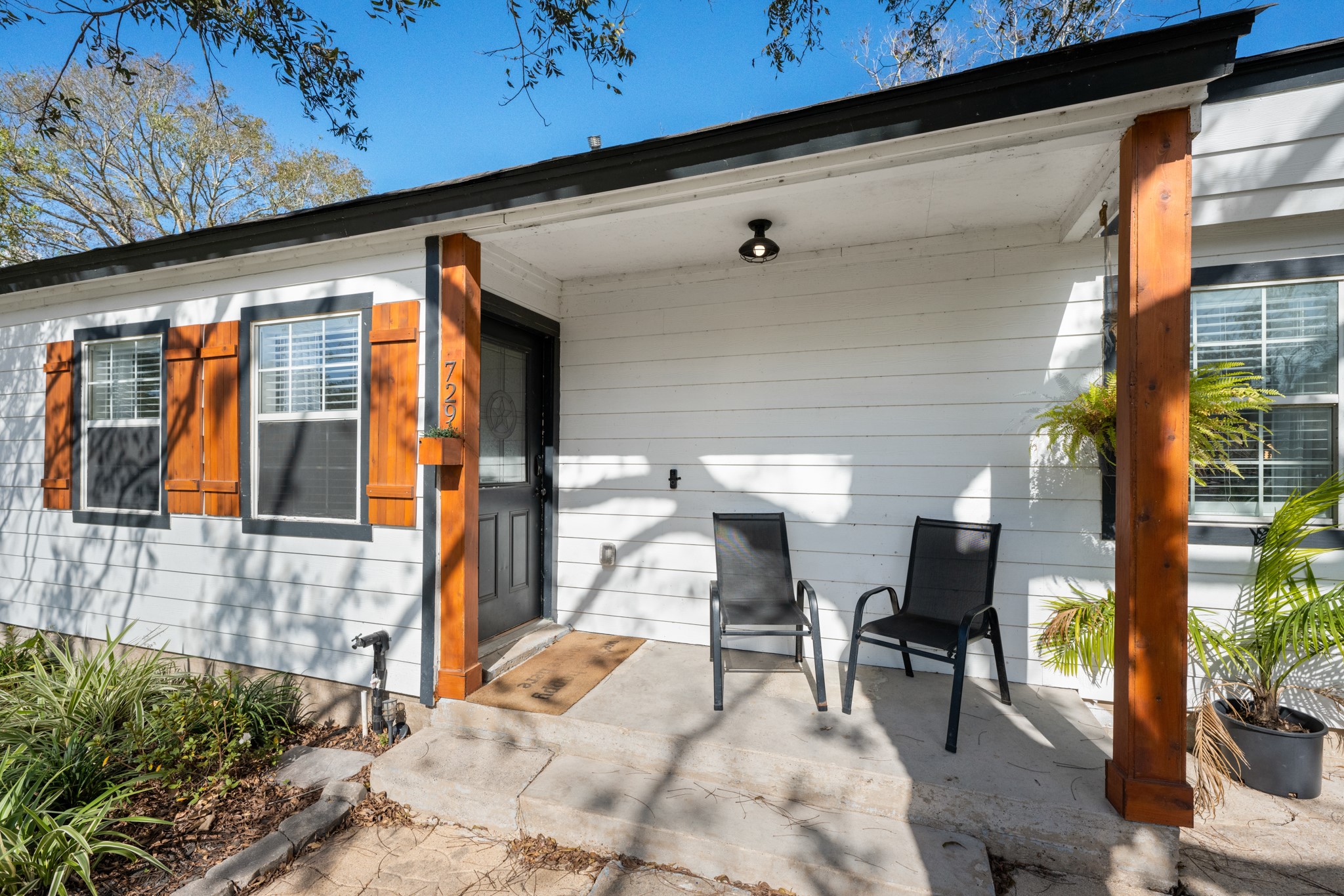 729 Kyle Angleton, TX 77515 - Photo 29 of 36 A cozy covered entry with space for seating, highlighted by warm wood posts and potted greenery—perfect for enjoying morning coffee or evening relaxation.
