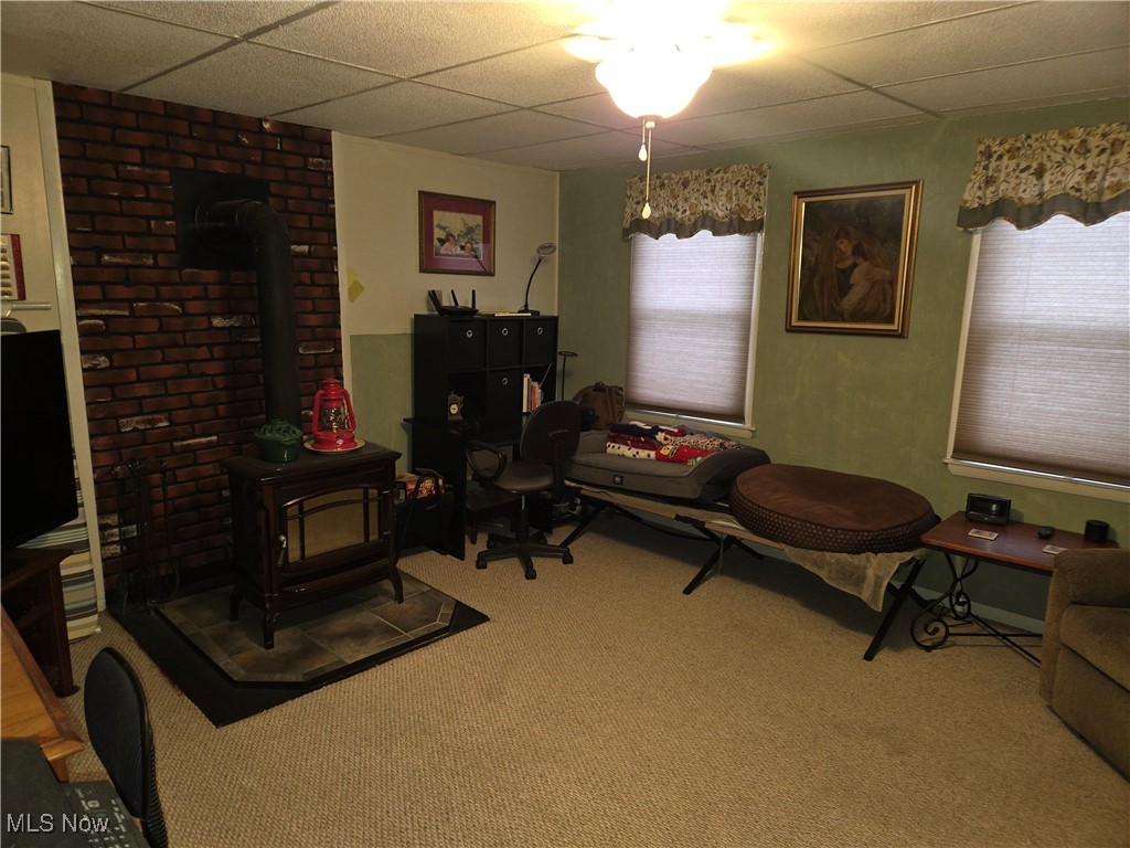 1962 Zenobia Road Norwalk, OH 44857 - Photo 13 of 30 Sitting room with a paneled ceiling, carpet flooring, a wood stove, and a wealth of natural light
