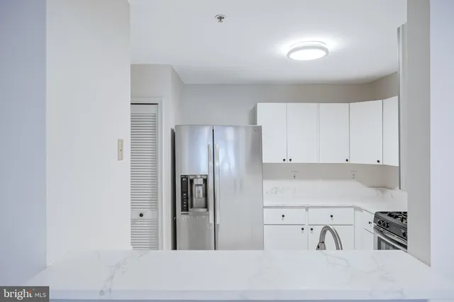 a kitchen with stainless steel appliances white cabinets and a refrigerator