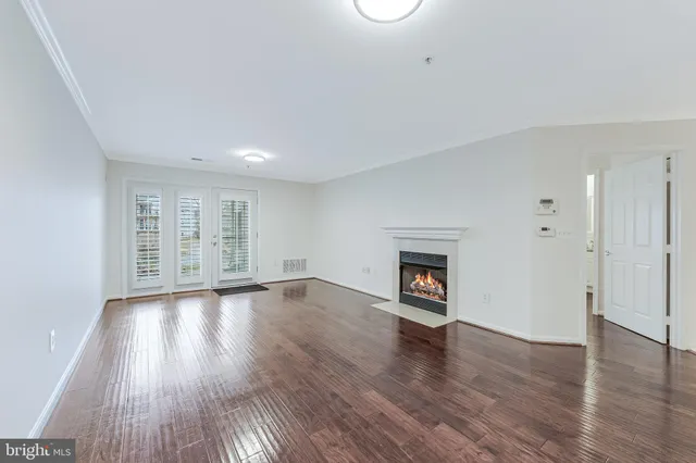 an empty room with wooden floor and fireplace