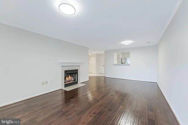 an empty room with wooden floor and fireplace