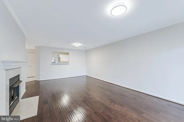 an empty room with wooden floor and a fireplace