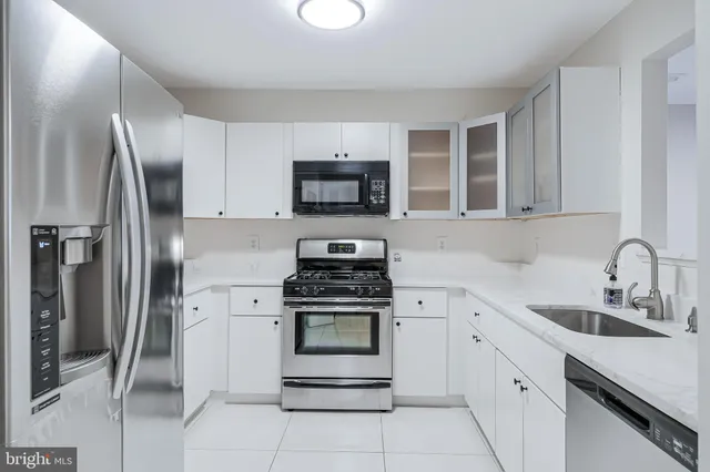 a kitchen with cabinets stainless steel appliances and a sink