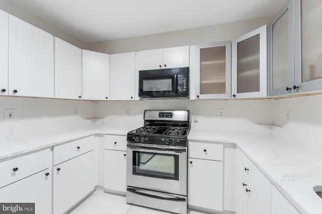a kitchen with white cabinets and appliances