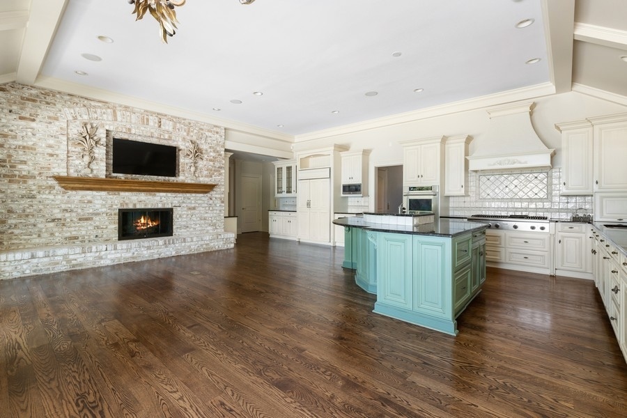 55 Stone Gate Road Lake Forest, IL 60045 - Photo 17 of 62 a kitchen with stainless steel appliances a stove top oven a sink dishwasher and a fireplace