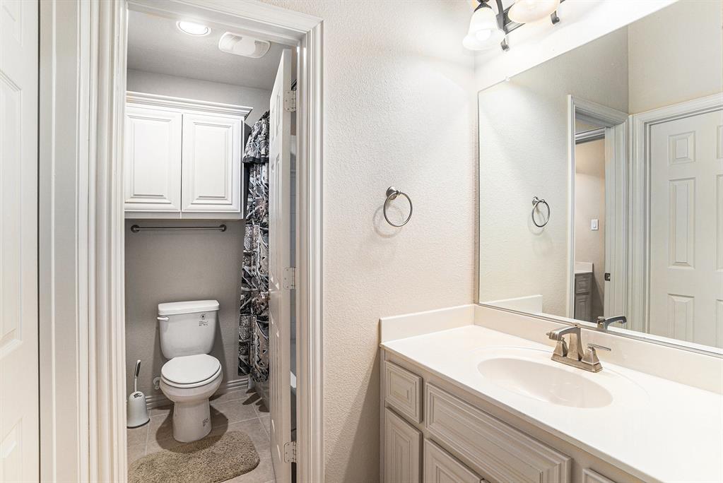 6132 Falls Lake Road Fort Worth, TX 76179 - Photo 24 of 37 a bathroom with a toilet a sink and a mirror