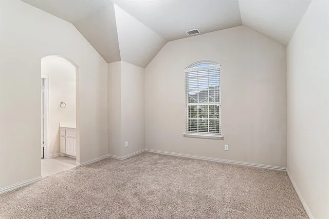 an empty room with closet and a chandelier fan