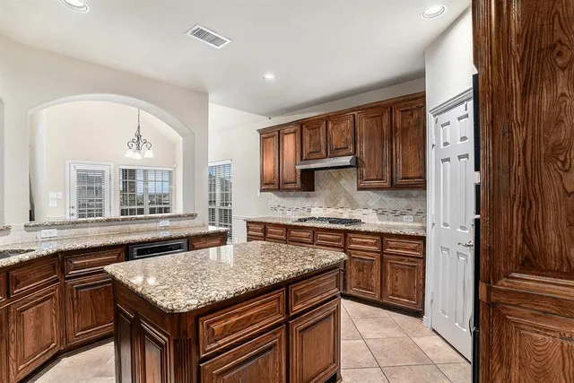 a kitchen with stainless steel appliances granite countertop wooden cabinets and a counter top space