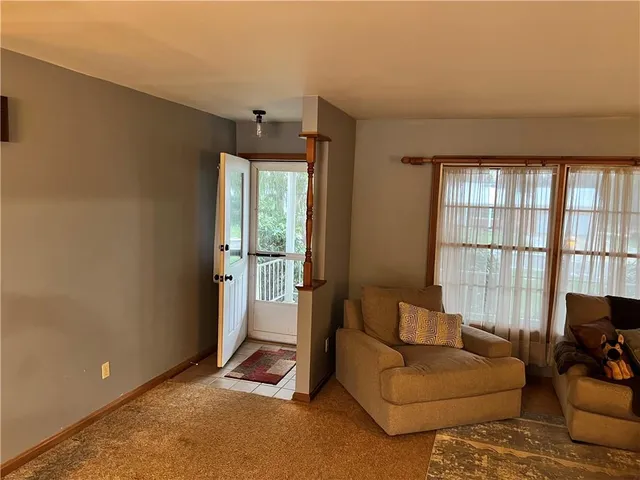 a living room with furniture and a floor to ceiling window