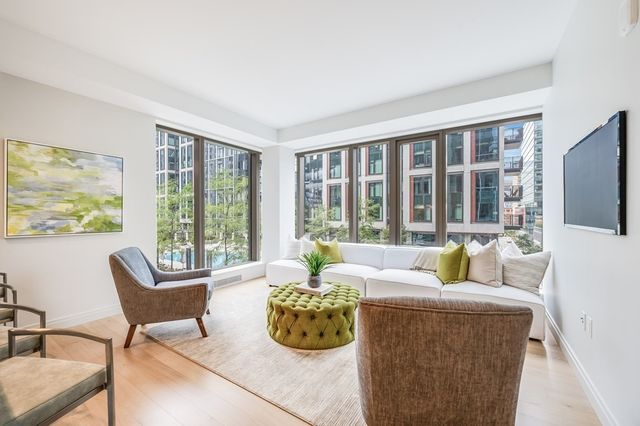 a living room with furniture large window and flat screen tv