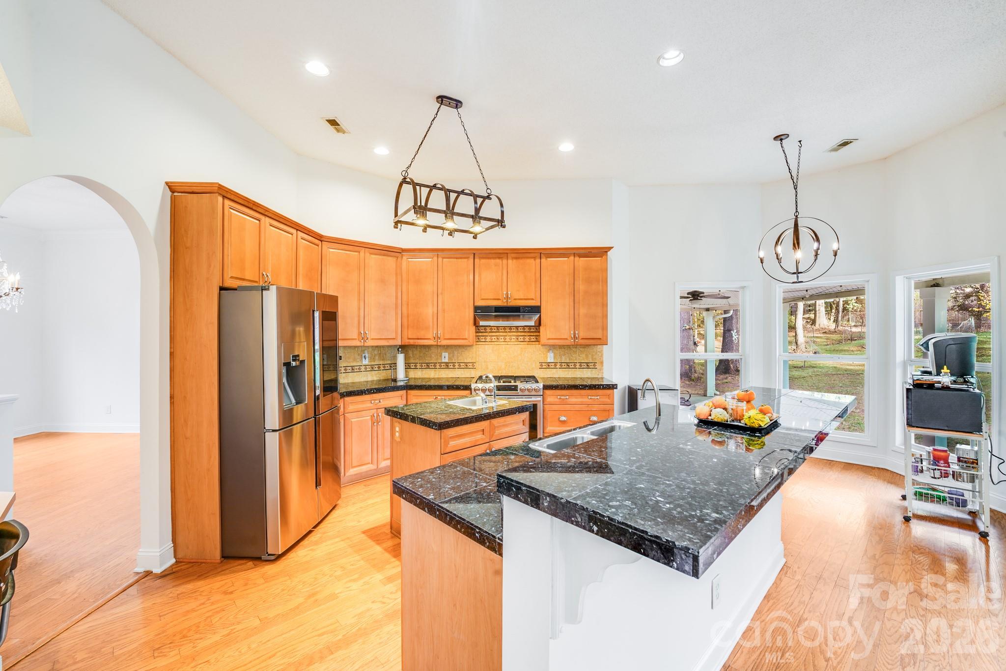 5329 Kuykendall Road Charlotte, NC 28270 - Photo 14 of 18 a kitchen with stainless steel appliances granite countertop a sink stove and refrigerator
