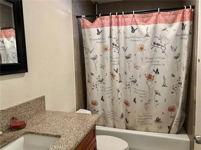 a bathroom with a granite countertop sink and a toilet