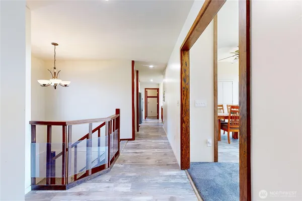 a view of a hallway with wooden floor and stairs