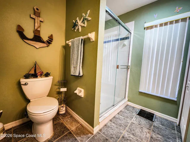 a bathroom with a toilet and a shower