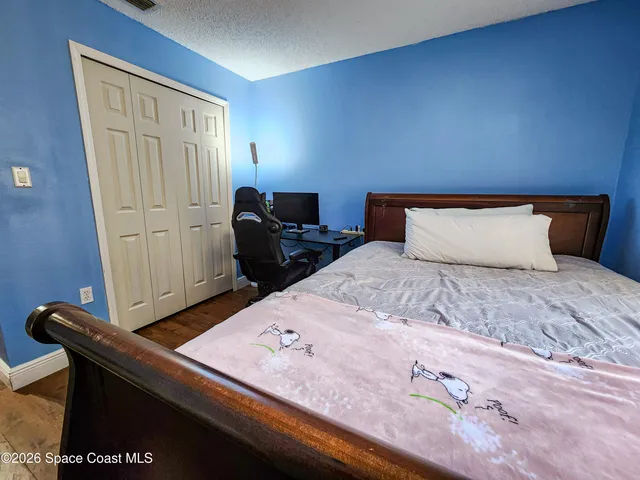 a bedroom with a bed and wooden floor