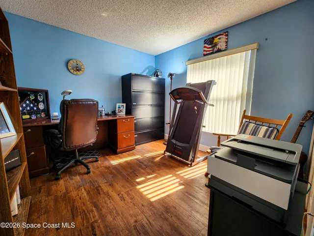 a view of workspace with wooden floor windows