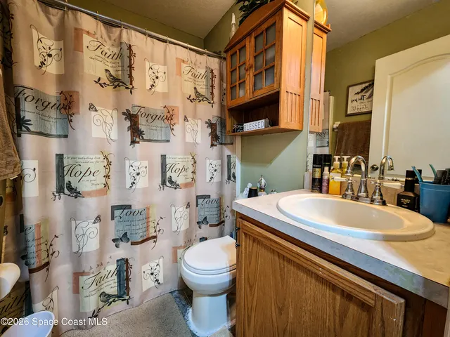 a bathroom with a sink a toilet and a large mirror