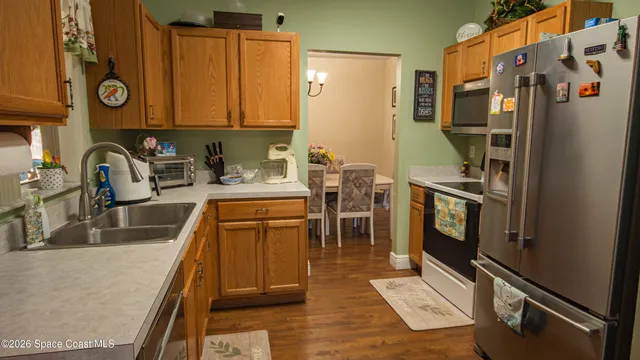 a kitchen with stainless steel appliances granite countertop a sink and a refrigerator