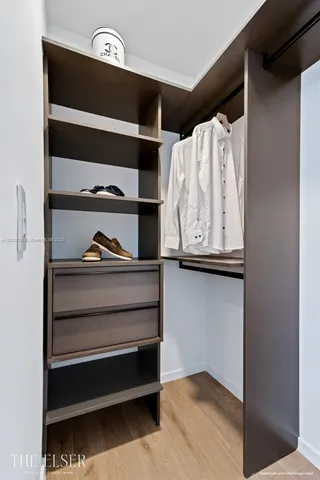 a view of walk in closet with clothes and shoes