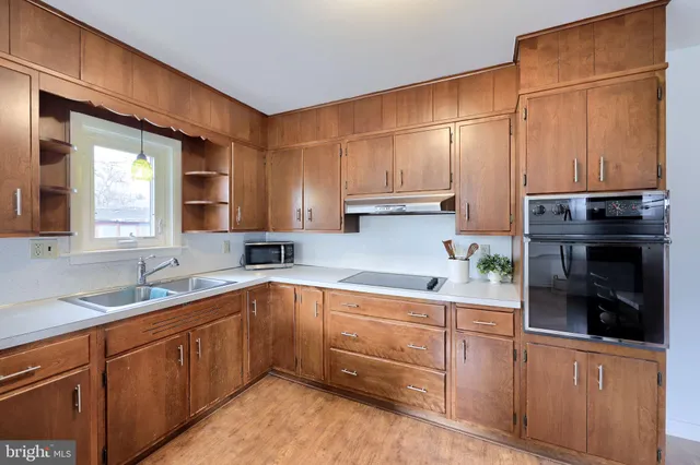a kitchen with stainless steel appliances granite countertop a sink a stove and cabinets