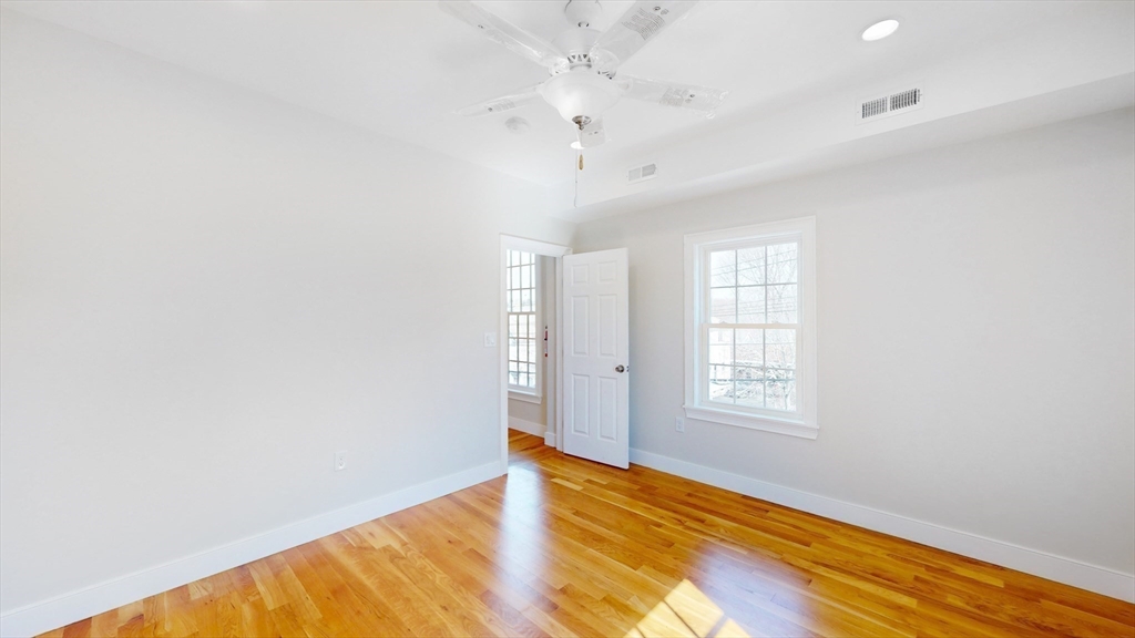 48 Rockwell Street, Unit 1 Malden, MA 02148 - Photo 15 of 34 an empty room with wooden floor and windows