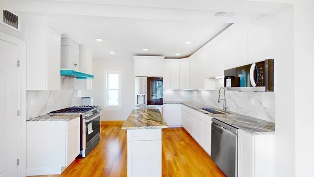 a kitchen with stainless steel appliances granite countertop a sink stove and refrigerator
